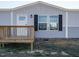 Front view of manufactured home with gray siding, white door and black shutters at 6545 Old Jefferson Davis Hwy, Cameron, NC 28326