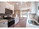 Modern kitchen with white cabinets, stainless steel appliances, and quartz countertops at 105 Tracey Creek Ct Ct, Apex, NC 27502