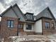 Two-story home with gray and brick exterior, and a covered front porch at 1401 Cottondale Ln, Wake Forest, NC 27587