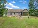 View of the house's back exterior and screened porch surrounded by lush, green lawn at 1813 Ferrell Meadows Dr, Zebulon, NC 27597