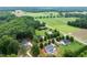 Aerial view highlighting properties with mature trees, lush lawns, and various architectural styles with a pool at 20 Tamaran Ct, Spring Hope, NC 27882