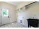Laundry room featuring tile flooring, a utility sink, and overhead cabinets at 20 Tamaran Ct, Spring Hope, NC 27882
