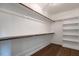 Spacious walk-in closet with custom shelving and hanging rods, and hardwood floors at 20 Tamaran Ct, Spring Hope, NC 27882