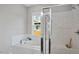 Modern bathroom featuring a tub, tile surround, a glass shower door and bright natural light at 224 Wash Hollow Dr, Wendell, NC 27591