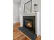 Close-up of a modern fireplace with a black surround, glass doors, and a decorative mantel at 224 Wash Hollow Dr, Wendell, NC 27591