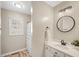Clean bathroom, featuring a vanity with a round mirror and shower/tub combo at 2773 Clifton Avenue, Creedmoor, NC 27522