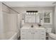Modern bathroom with white vanity, a tub, and updated lighting at 2773 Clifton Avenue, Creedmoor, NC 27522