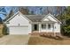 White house with brick accents, a two-car garage, and a covered front porch at 2773 Clifton Avenue, Creedmoor, NC 27522