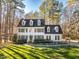 Two-story white house with green shutters, a manicured lawn, and mature trees at 3 Acornridge Ct, Durham, NC 27707