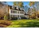 Two-story white house with green shutters, a manicured lawn, and mature trees at 3 Acornridge Ct, Durham, NC 27707