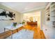 Home office with built-in shelving, hardwood floors and view into living room at 3 Acornridge Ct, Durham, NC 27707