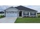 House exterior with stone accents, a two-car garage, and a well-manicured lawn at 40 Northwood Dr, Fuquay Varina, NC 27526