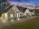 Charming ranch-style home features a stone facade, covered porch, and a long driveway with ample parking at 413 Johnson Town Rd, Zebulon, NC 27597