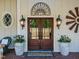 Elegant double front door with decorative accents, sconces, and potted plants for a warm welcome at 413 Johnson Town Rd, Zebulon, NC 27597