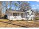 Gray sided ranch home with white brick skirt, covered porch and mature trees at 420 W 10Th St, Siler City, NC 27344