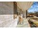 Relaxing front porch with wooden bench and white brick exterior at 420 W 10Th St, Siler City, NC 27344