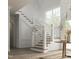 Grand staircase with white railings and wood flooring adds to the home's elegance at 432 Firefly Overlook, Pittsboro, NC 27312