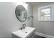 Updated bathroom vanity features a matte black faucet, round mirror and updated vanity lights at 601 Rose St, Rocky Mount, NC 27801