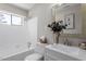 Clean bathroom with white vanity, bathtub, and tiled shower at 609 E Cockrell St, Nashville, NC 27856