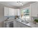 Modern kitchen with white cabinets, granite counters, and stainless steel appliances at 609 E Cockrell St, Nashville, NC 27856