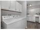 Dedicated laundry room with white appliances and ample cabinet space, enhancing functionality at 635 Pine Ridge Pl, Raleigh, NC 27609