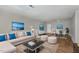 Open-concept living room featuring a modern sectional sofa, decorative rug, and adjacent dining area with bright natural light at 635 Pine Ridge Pl, Raleigh, NC 27609