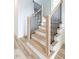 Modern light oak staircase with black metal railing and white risers at 707 Colleton Rd, Raleigh, NC 27610