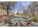 Stone firepit surrounded by comfortable wooden chairs in backyard at 7112 Hasentree Way, Wake Forest, NC 27587