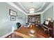 Bright home office with built-in bookshelves, a large desk, and hardwood floors at 7112 Hasentree Way, Wake Forest, NC 27587