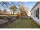 Home's backyard featuring a small deck, concrete wall, and grassy area at 8 Kingston Mill Ct, Durham, NC 27701