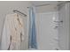 Bathroom features a shower with blue decorative curtains, a clean white tub and shelves at 8 Kingston Mill Ct, Durham, NC 27701