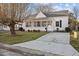 Home exterior with a screened-in porch, small bushes, large tree and concrete walkway at 8 Kingston Mill Ct, Durham, NC 27701