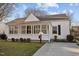 Charming home exterior with a screened-in porch, small bushes and a concrete walkway at 8 Kingston Mill Ct, Durham, NC 27701