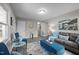 Bright living room with neutral walls, gray sofa, blue accents, and wood-look flooring at 8 Kingston Mill Ct, Durham, NC 27701