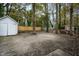 Large, unfenced backyard with mature trees and detached white storage shed at 925 Redgate Ave, Rocky Mount, NC 27801