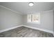 Bedroom featuring wood-look flooring and paneled walls at 925 Redgate Ave, Rocky Mount, NC 27801