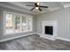 Inviting living room featuring a brick fireplace, large windows, and wood-look floors at 925 Redgate Ave, Rocky Mount, NC 27801