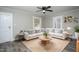 Cozy living room featuring a ceiling fan, rug, white sofa, and natural light from two windows at 925 Redgate Ave, Rocky Mount, NC 27801