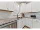 White kitchen cabinets, granite counters, stainless steel dishwasher at 107 York Dr, Oxford, NC 27565