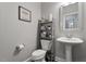 Clean and modern powder room with pedestal sink, toilet, and shelving at 1109 Timbercut Dr, Durham, NC 27703
