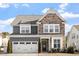 Two-story home with stone and shingle accents, two-car garage, and landscaping at 1109 Timbercut Dr, Durham, NC 27703