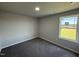 Bright bedroom with grey carpet and large window at 16 Shiloh Dr, Lillington, NC 27546