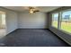Open living room with gray carpet, neutral walls, and large windows at 16 Shiloh Dr, Lillington, NC 27546