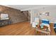 Living room featuring hardwood floors and brick accent wall at 220 Elizabeth St # Apt D5, Chapel Hill, NC 27514