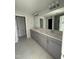 Bathroom featuring a double vanity with modern fixtures, a large mirror, and tile flooring at 2405 Englemann Dr # 121, Apex, NC 27502