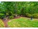 Well-maintained backyard with lush green grass and mulched garden beds at 241 Serenity Hill Cir, Chapel Hill, NC 27516