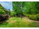 Green backyard with trees, landscaping, and a birdbath at 241 Serenity Hill Cir, Chapel Hill, NC 27516