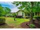Landscaped backyard with green lawn, mature trees, and a view of the home at 241 Serenity Hill Cir, Chapel Hill, NC 27516