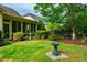Landscaped backyard with green lawn, mature trees, and a view of the home at 241 Serenity Hill Cir, Chapel Hill, NC 27516