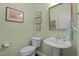 Charming powder room with a pedestal sink, decorative mirror, and stylish fixtures at 241 Serenity Hill Cir, Chapel Hill, NC 27516